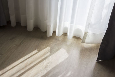 High angle view of white curtain on hardwood floor