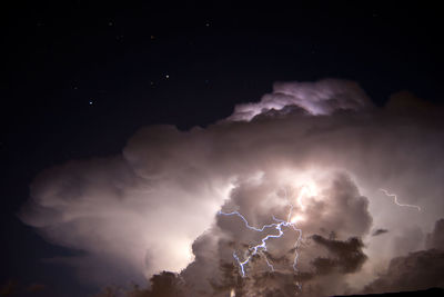 Low angle view of stormy clouds at night