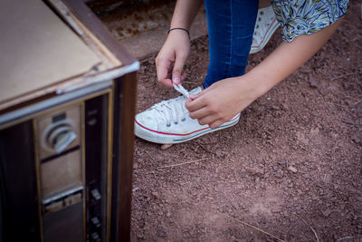 Low section of woman tying shoelace