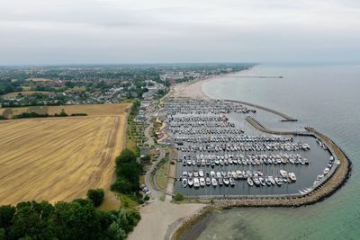 High angle view of city by sea against sky