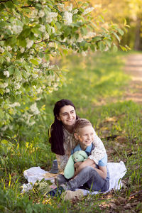 Cute boy with mom on a picnic. son hugs mom