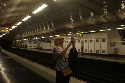 Rear view of woman standing in subway