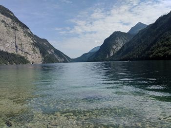 Scenic view of lake by mountains against sky