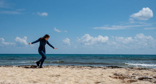 Man standing at beach against sky