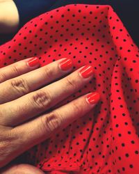 Close-up of woman hand on red table