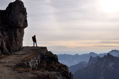Man standing on mountain against dramatic sky