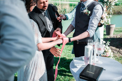 Rear view of people standing by glass