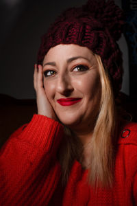 Close-up portrait of smiling beautiful woman wearing red sweater