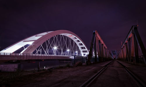 Illuminated bridge against sky at night