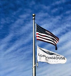 Low angle view of flags sign against sky