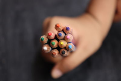 High angle view of hand holding multi colored candies