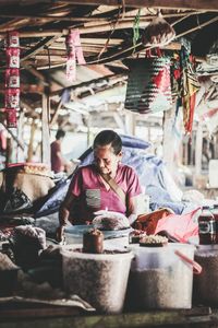 Full length of young man having food at market stall