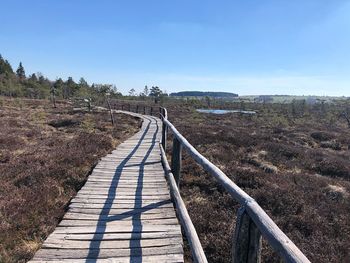 Footpath by railing against sky