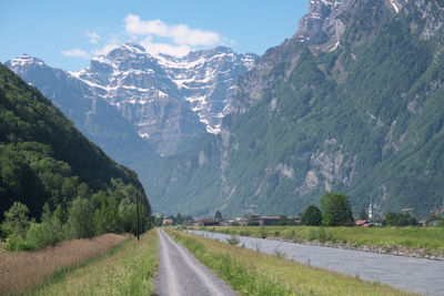 Road leading towards mountains against sky