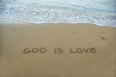 High angle view of text on sand at beach