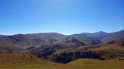 Scenic view of mountains against clear blue sky