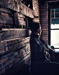 Man looking away while sitting on wall