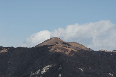 Low angle view of volcanic mountain against sky