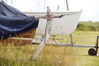 Ship moored on field against sky