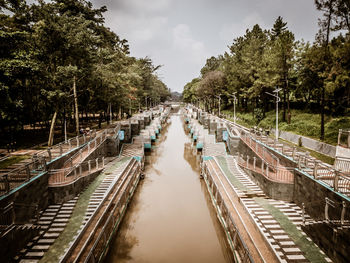 Panoramic view of canal amidst trees against sky