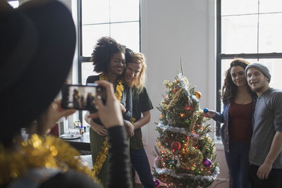 A group of people taking a photo with a christmas tree