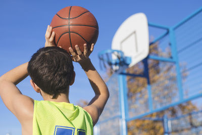 Low angle view of boy playing basketball