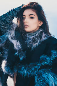 Portrait of young woman standing against sky during winter