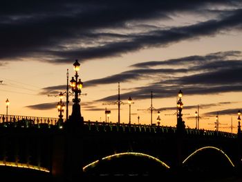 Illuminated bridge against sky at sunset
