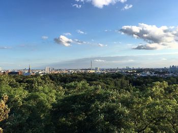 Trees and cityscape against sky