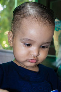 Cute infant in serious mode busy in something at day from flat angle