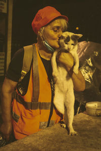 Portrait of man with dog sitting on floor at night