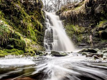 Low angle view of waterfall against sky