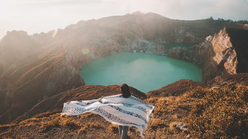 Woman standing on mountain against lake