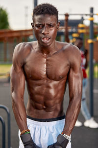 Portrait of shirtless man exercising in gym