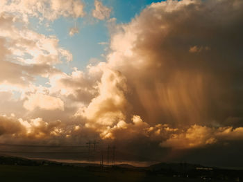 Low angle view of electricity pylon against sky during sunset