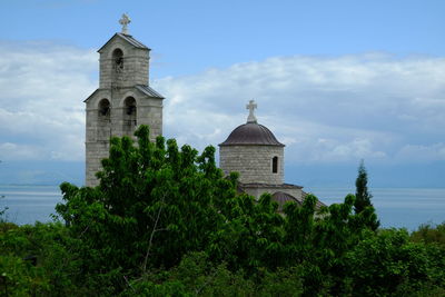 Church by sea against sky