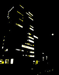 Low angle view of illuminated buildings against sky at night