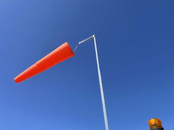 Low angle view of telephone pole against clear blue sky