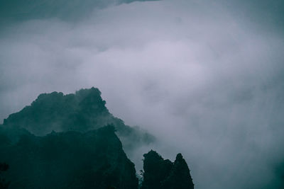 Low angle view of silhouette mountains against sky