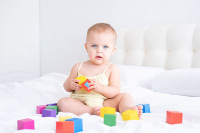 Portrait of cute baby boy playing with toy blocks at home