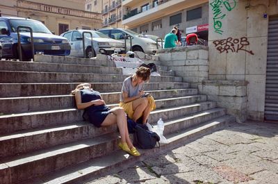 People sitting on staircase in city