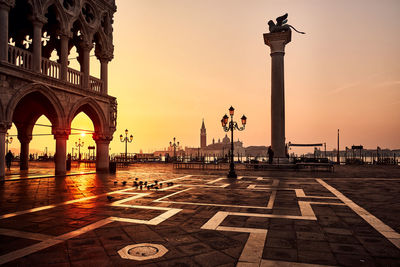 Statue in city during sunset