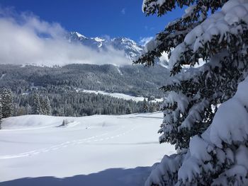 Scenic view of snowcapped mountain against cloudy sky