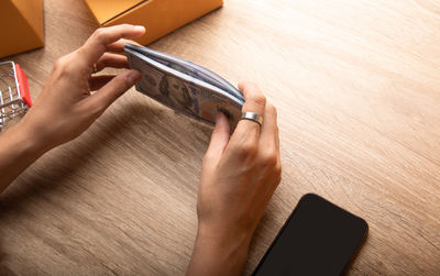 Midsection of man using mobile phone on table