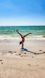 Full length of woman jumping at beach