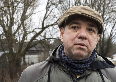 Adult man in a cap in a winter park