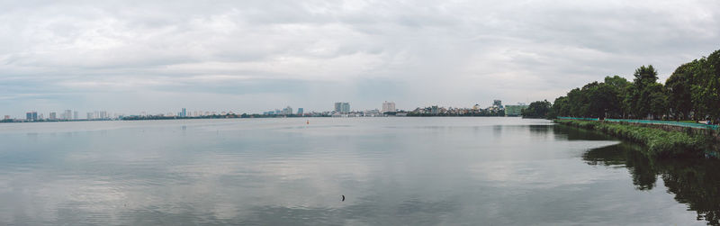 Scenic view of river against sky in city