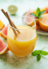 Glass of juice and fresh citrus fruits