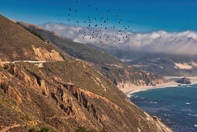 Scenic view of sea and mountains against sky