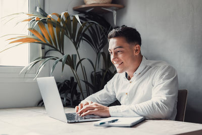 Young woman using laptop at table